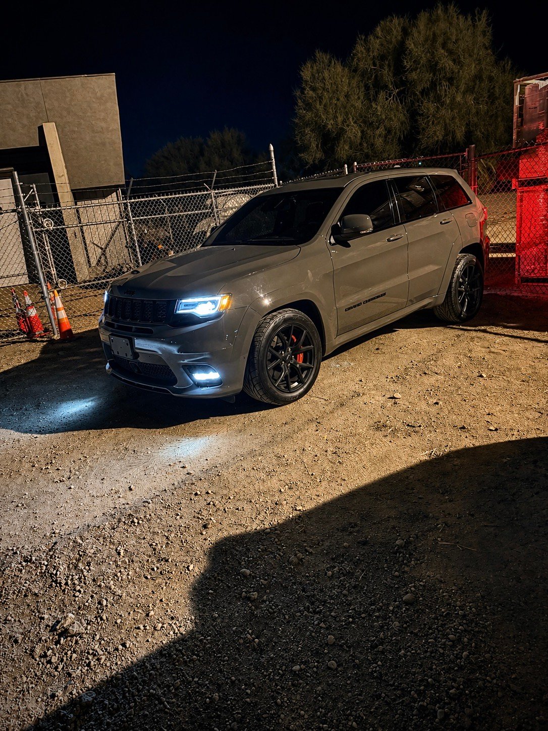 Jeep Grand Cherokee SRT at night with headlights illuminated